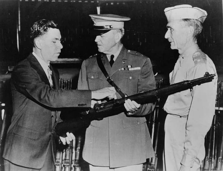 John Garand (left) points out features of the M1 to army generals.