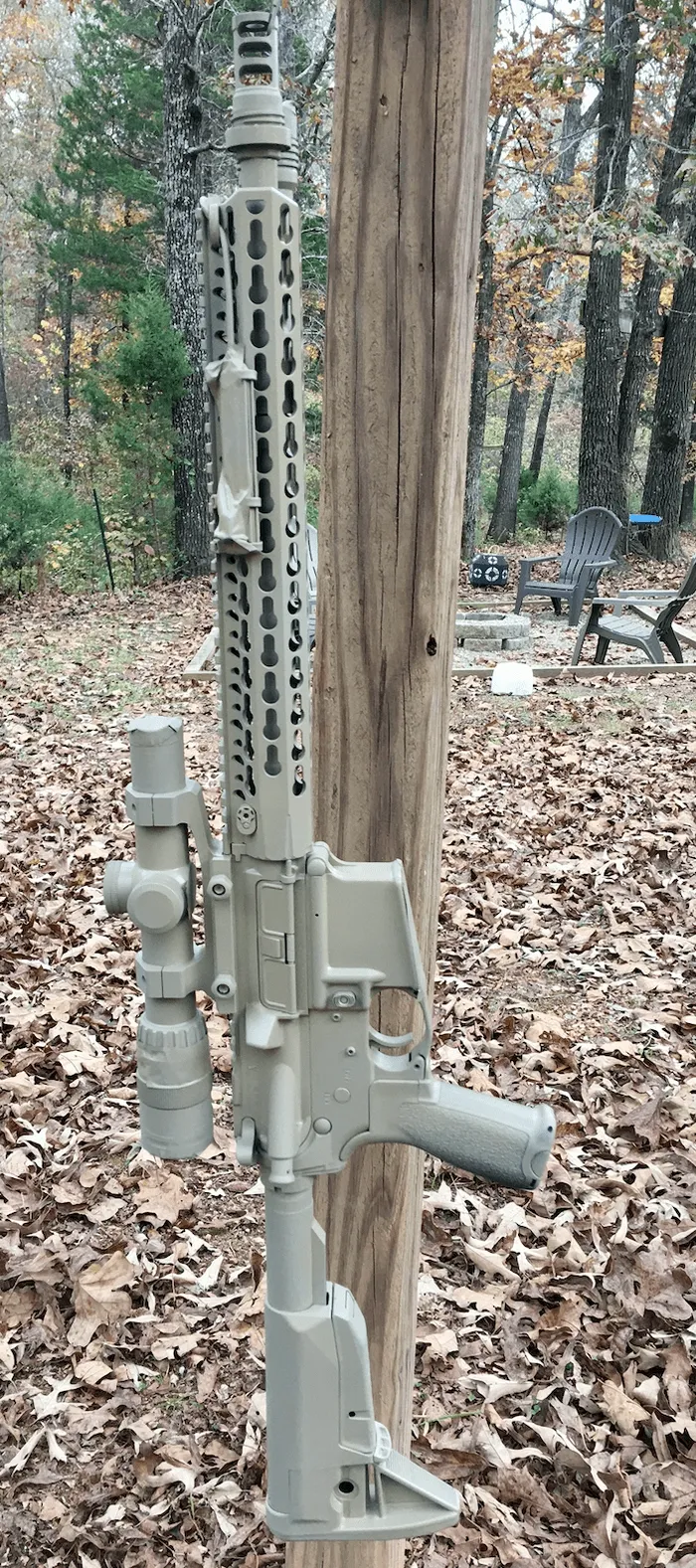 camo ar15 hanging on post for spray painting