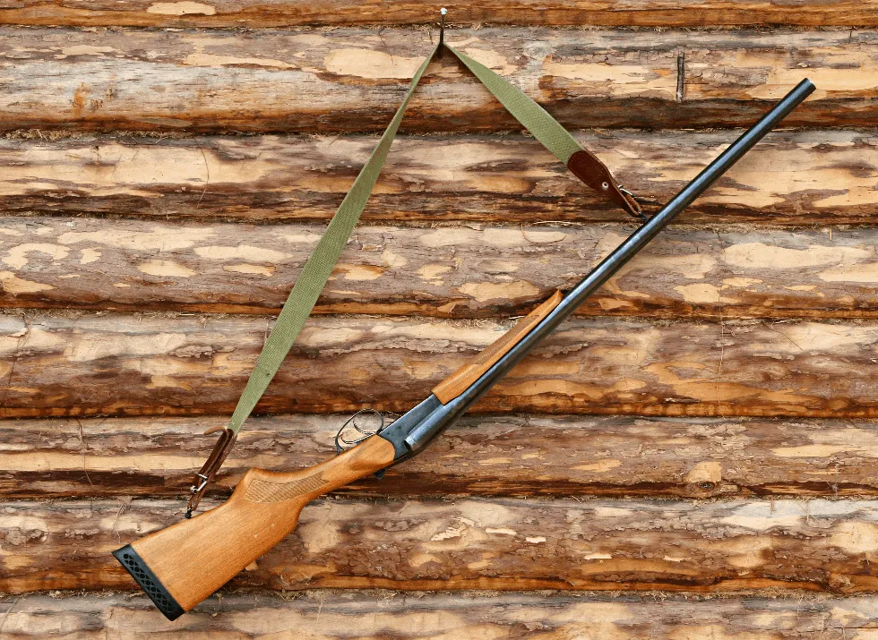 shotgun hanging on wood cabin