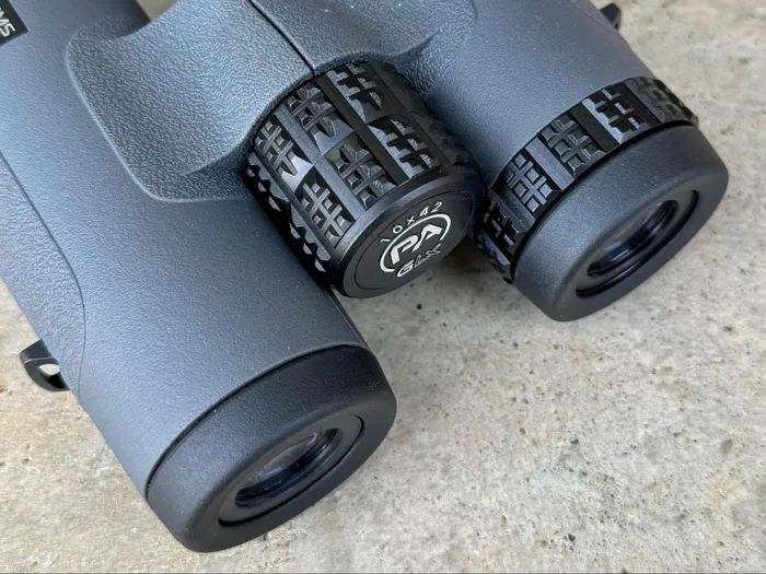 Close-up view of the GLx binoculars focusing on the detailed knurling on the adjustment knobs